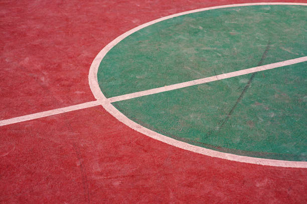 Asian hijab girl is playing basketball in the court.