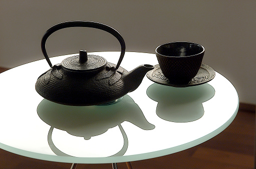 japanese teapot and iron cup on a glass table