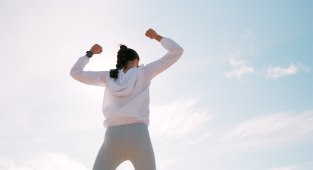 Back, exercise and winning with woman, cheering and fitness with goals and achievement. Person, girl and athlete with accomplishment or success with sky background or victory with training or workout