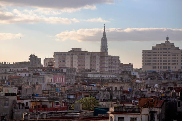 A roof top view looking at a church spire and buildings in central Havana at the end of the day