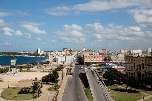 Looking down on a road that runs into old Havana, with the ocean to one side on a sunny day