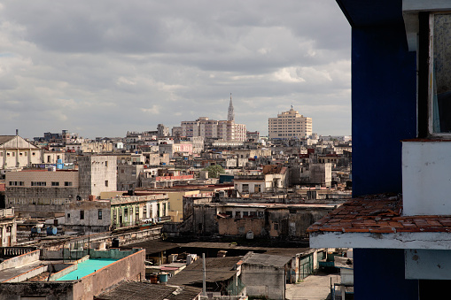 A view from a balcony looking out over the rood tops of central Havana, with a church spire in the distance