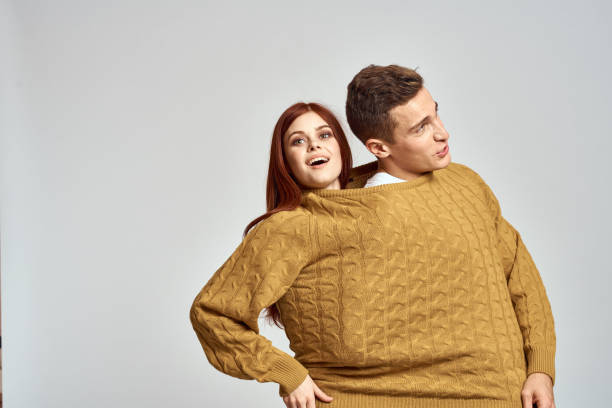 istock couple in yellow sweater posing against light background cropped view 2136327636