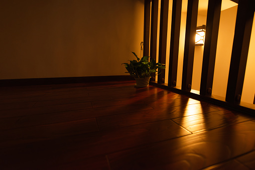 The light shone through the railing on the wooden floor.