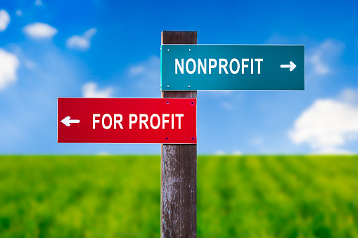 Nonprofit vs For Profit - Traffic sign with two options - subsidized unprofitable organization with no income vs entrepreneurship and business based on earning money. Charity vs capitalization