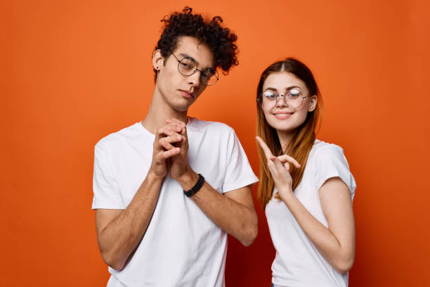 istock cheerful young couple wearing glasses communication isolated background 2136400754