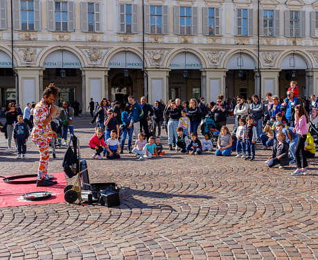 Turin, Piedmont, Italy - April 1, 2024: People watching a street performer in piazza San Carlo (Saint Charles Square).