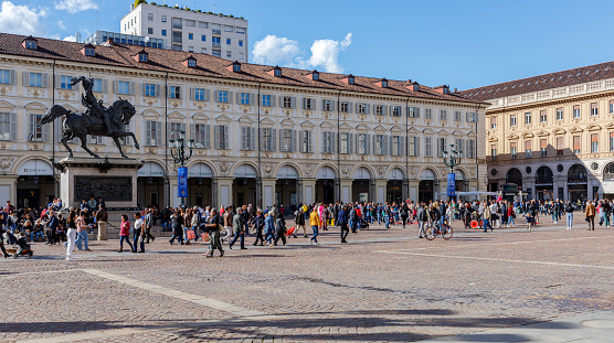Turin, Piedmont, Italy - April 1, 2024: People and tourists walking in piazza San Carlo (Saint Charles Square), and the monument to Emmanuel Philibert, Duke of Savoy.
