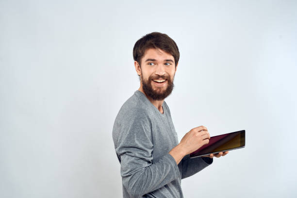 istock A bearded man with a tablet in his hands a gray jacket technology internet light background 2136449682