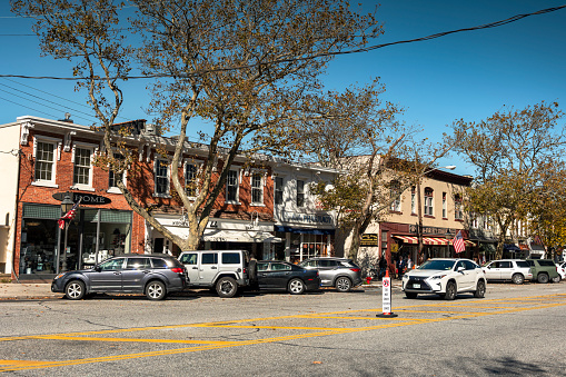 Sag Harbour, New York - October 27, 2022:  Cars and people shop along the Main Street in the downtown village of Sag Harbor in The Hamptons Long Island. Sag Harbor is an incorporated village in Suffolk County.