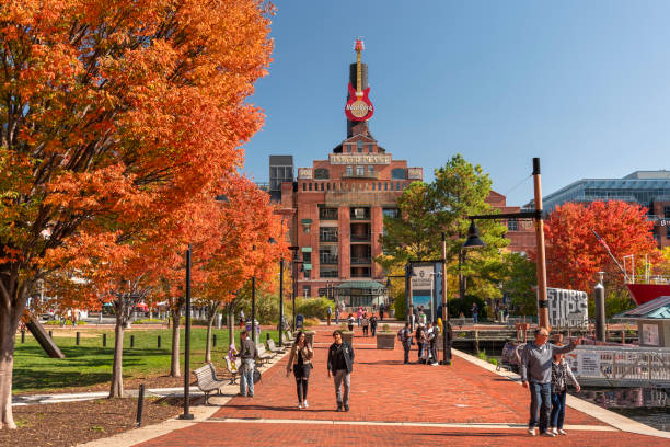 Baltimore, Maryland USA - October 29, 2022:  People walk along the boardwalk paths and downtown marina on the Inner Harbor of Baltimore Maryland flowing out to the Patapsco River and Chesapeake Bay