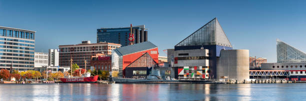 Baltimore, Maryland, USA - October 30, 2011: Exterior of the National Aquarium in the Inner Harbor in Baltimore, Maryland.  The Lighship Chesapeake and the submarine Torsk are moored in front of the aquarium.  The Hard Rock Cafe guitar sign can be seen in the background.  There is a water taxi parked in front of the building.