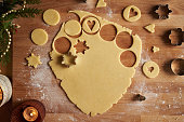 Cutting out star shapes from rolled out dough to prepare homemade Linzer Christmas cookies