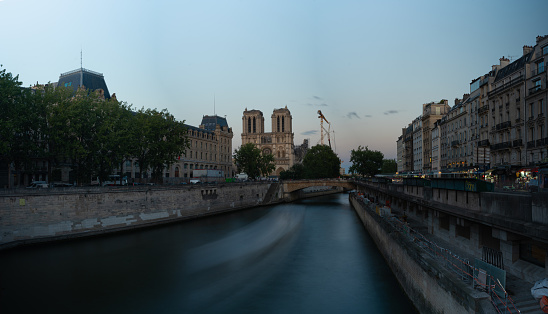Panoramic photo in low exposure of a boat in a canal of the Seine River in the old area of the capital of France. Paris. France. August 6, 2023