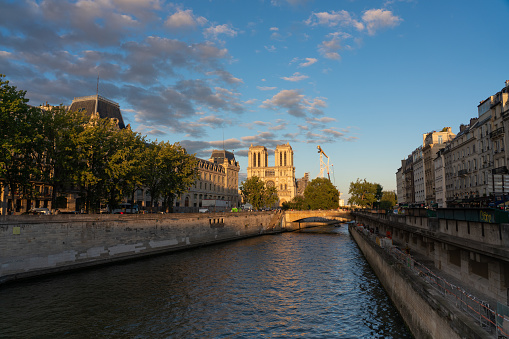 Sunset photo of a canal of the Seine River with the Notre Dame Cathedral in the background. Paris. France. August 6, 2023
