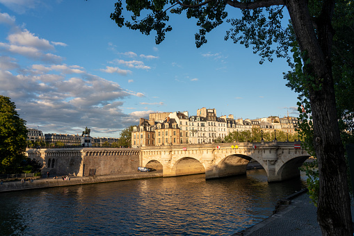 Evening light falling on Pont Neuf a historical monument on the Seine River. Paris. France. August 6, 2023.