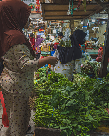 Balikpapan, Indonesia - March 15th, 2024. there are some market vendors selling fresh vegetables and fruits inside the traditional market iin Klandasan.