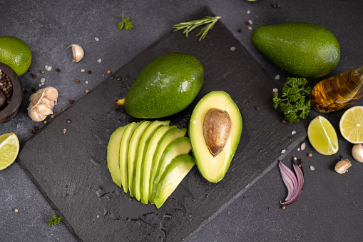Green Avocado on stone serving board.