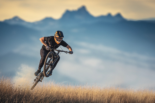 Mountain biker riding in the mountains and jumping.