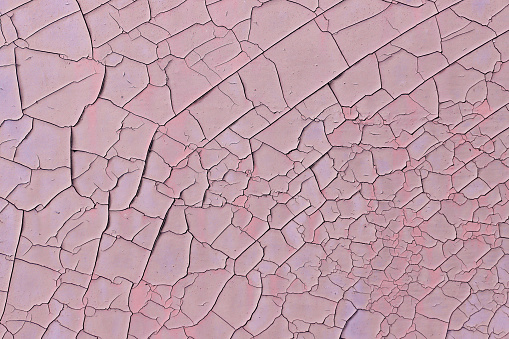 A pattern with the effect of dried and aged pink paint cracks.
