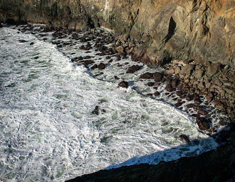Rocky cliff along coastal waters