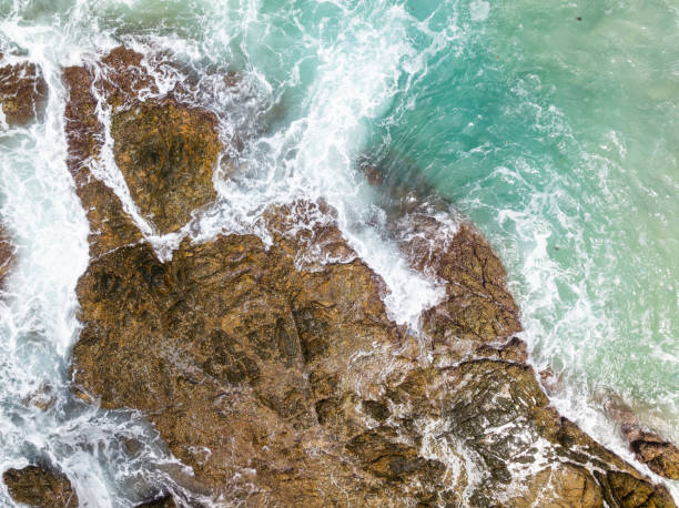 istock Waves crashing on seashore rocks,Top view sea surface waves background 2136724204