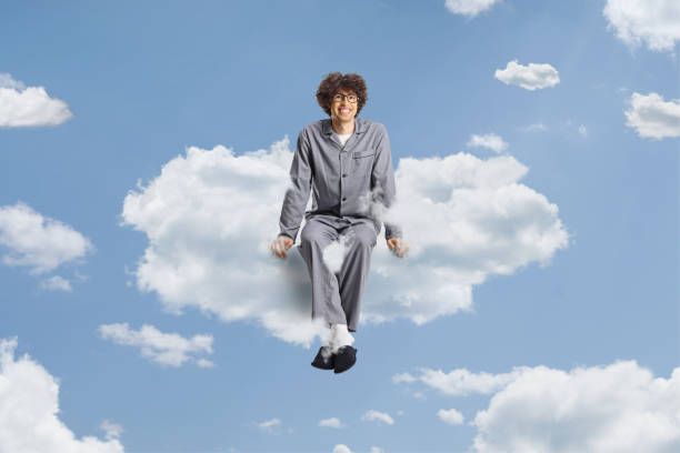 istock Young man in pajamas floating on a cloud 2136756051