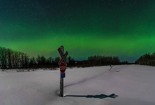 The Aurora Borealis or Northern Lights dance above a snowcovered rail line in northern Ontario.