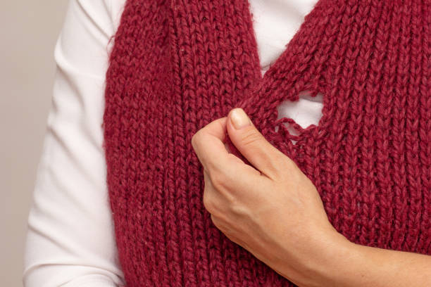 istock Woman hand holding knitted thing with hole made by moth 2136759765
