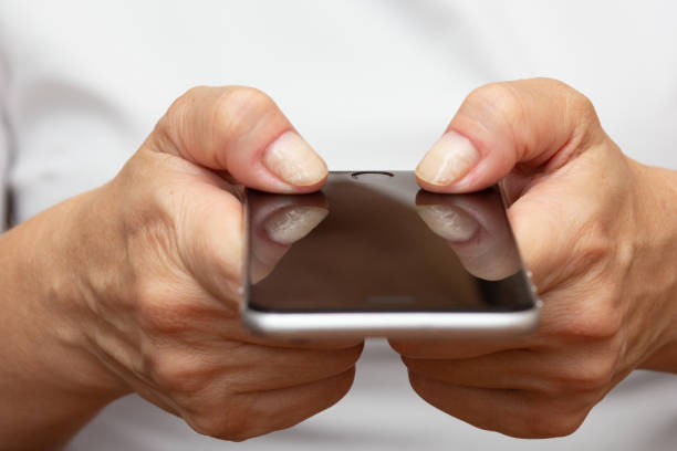istock Woman hands holding smartphone concept Arthritis over cropped body 2136759769