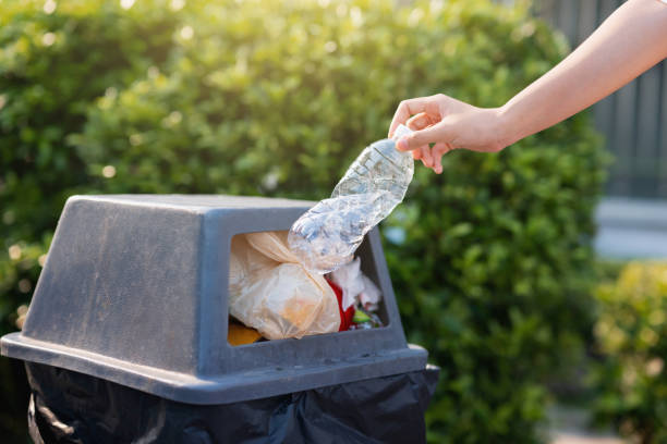 istock person is throwing away a plastic bottle in a trash can 2136761969