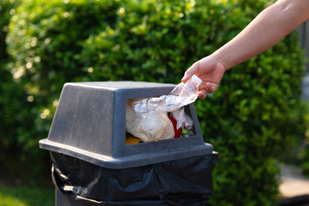 istock person is throwing away a plastic bottle into a trash can 2136764163