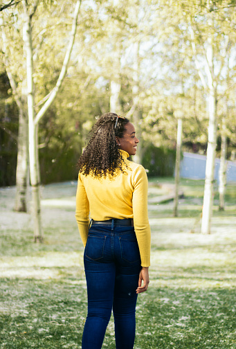 back view of a afro-american girl walking in a park