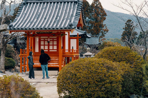 Miyajima, Japan - April 27, 2014: View of pilgrims visiting Itsukushima Shrine. This is a shinto shrine located on the island of Itsukushima (or Miyajima), best known for its \