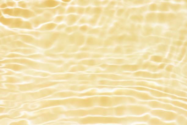 Bluewater waves on the surface ripples blurred. Defocus blurred transparent blue colored clear calm water surface texture with splash and bubbles. Water waves with shining pattern texture background.