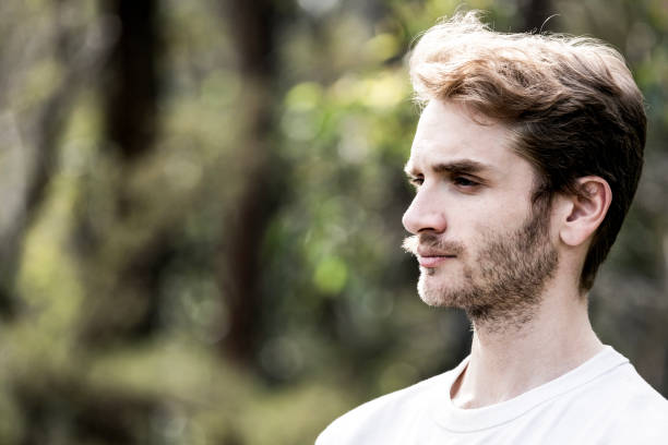 Portrait of serious young man, side view, background with copy space, full frame horizontal composition