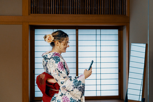 Female tourist trying a kimono experience at a shrine while on vacation in Japan