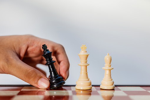 Businessman's hands move chess pieces and checkmate during competition, successful business competition concept.