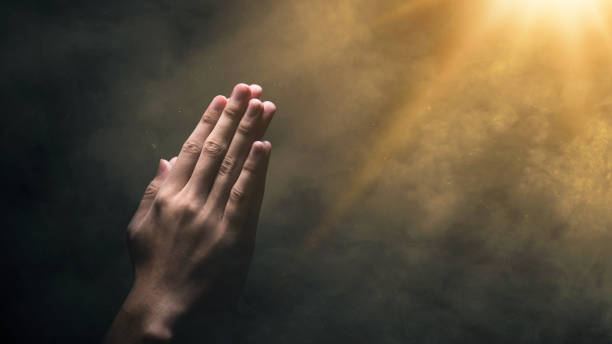 istock Christian man praying with raised hands 2136983099