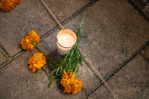 Yellow Marigold Flowers for Day of the Dead Mexico with a candle on the ground in Playa del Carmen, Mexico.