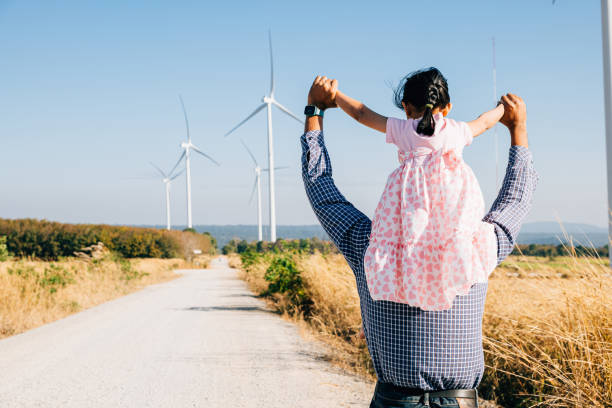 istock Father joyfully carries daughter exploring wind farm 2137050538