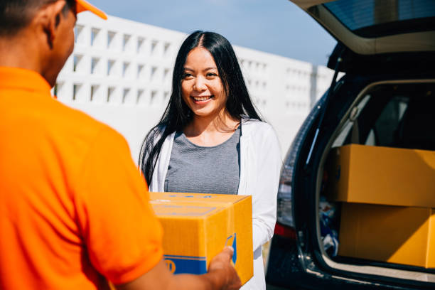 istock Efficient home delivery logistics depicted as a courier delivers a cardboard parcel to a smiling woman 2137050548