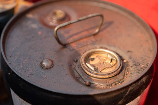 Close-up at chemical liquid drum or barrel bottle cap which is lock seal at the outlet hole. Industrial equipment object, selective focus.