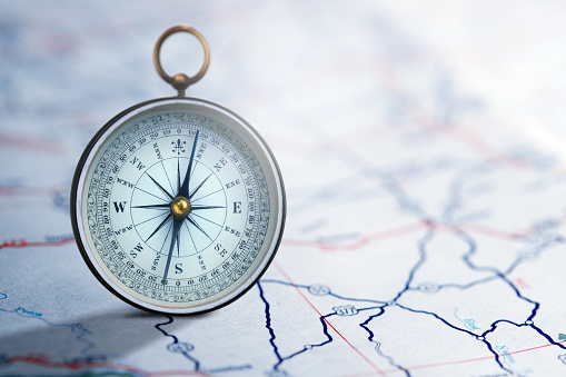 A standing compass on a generic road map.