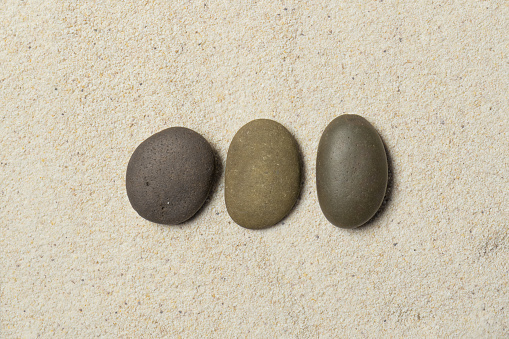 Top view of three stones resting on sandstone balance concept, Japanese Zen garden.