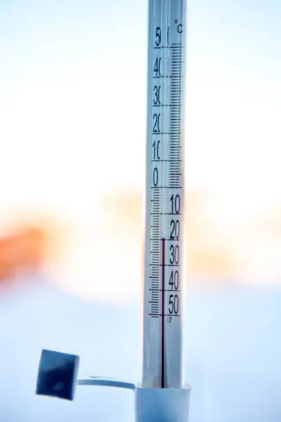 Photo of 20 degrees below zero Celsius on outdoor thermometer,  which is taped to window glass on street side.