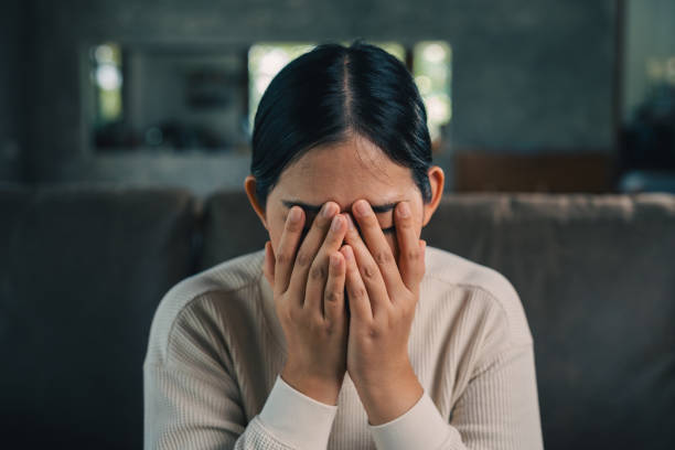 istock Depressed and Stressed asian woman on sofa. Crying sadness female alone in home problem in life. Unhappy asian woman headache Upset frustrated by problem love relationship feeling despair and anxiety 2137106564