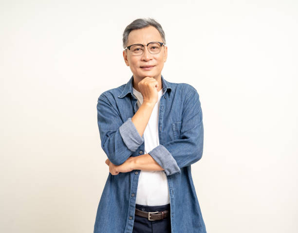 istock Handsome asian mature old man standing pose thinking on isolated white background. Happy Portrait of cheerful smiling senior asian man looking at camera. Mature People and lifestyle 2137122372