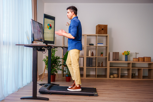 Man at Standing Desk Home Office Talking on Business Video Call
