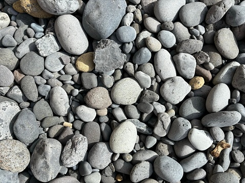Gray color pebbles isolated close-up on a wild beach in El Medano, Tenerife, Canary Islands, Spain, no people